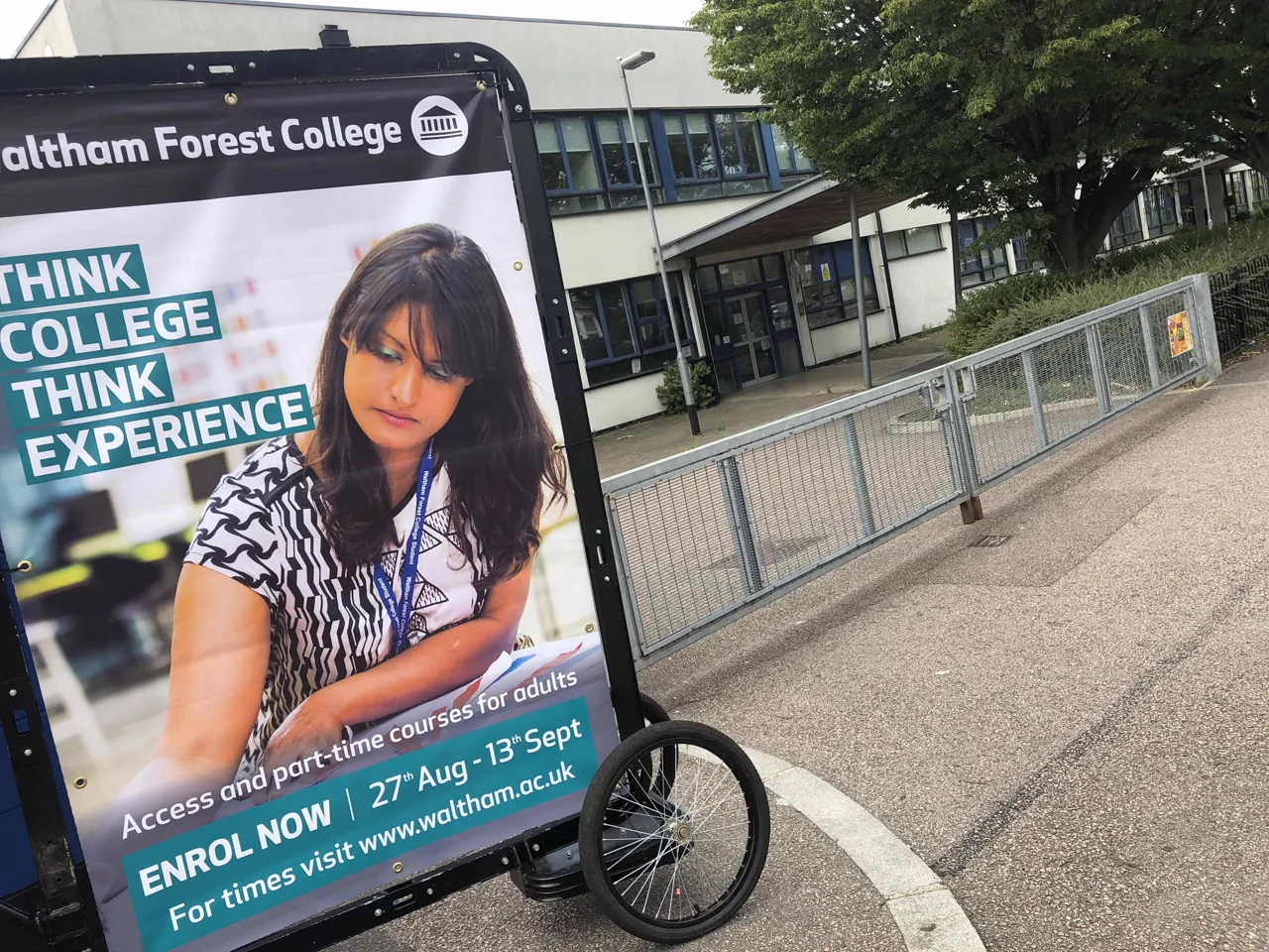 Waltham Forest College enrolment creative on an advertising bike outside an education building